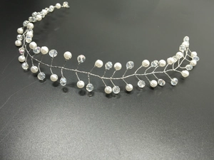 Close-up of handmade bridal headband with white pearls and crystals on silver wire