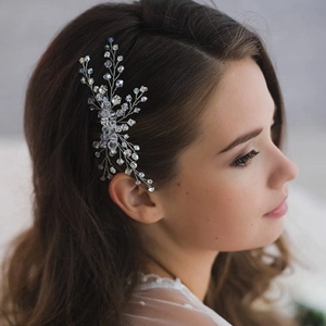 Detail showing hand-beaded bridal hair pin with silver wire and blue crystals