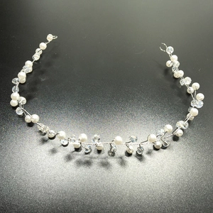 Close-up of handmade bridal hair vine with white pearls and crystals on silver wire