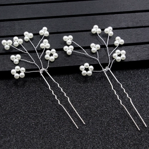 Détail d'épingles à cheveux de mariée avec perles blanches et fils d'argent tordus