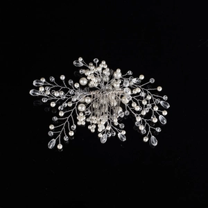 Macro shot of silver wedding hair comb featuring white pearls and clear crystals