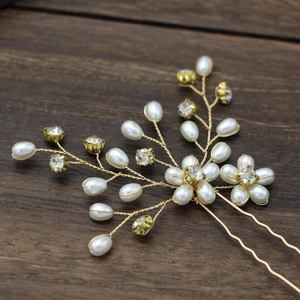 Handmade bridal hair pin with pearls and crystal flowers on elegant wood background