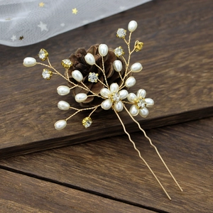 Detail of bridal hair pin with golden flower pearls and sparkling crystal rhinestones