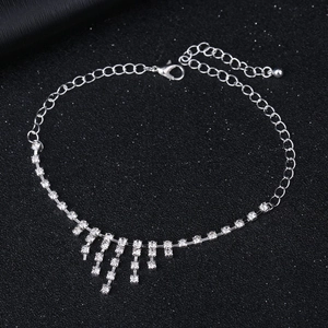 Detail eines silbernen Strass-Fußkettchens mit Quastenfransen und verstellbarem Karabinerverschluss