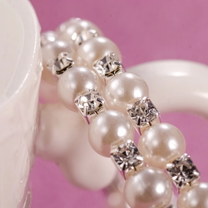 Macro detail of elastic bridal bracelet with 6mm pearls and square crystal settings