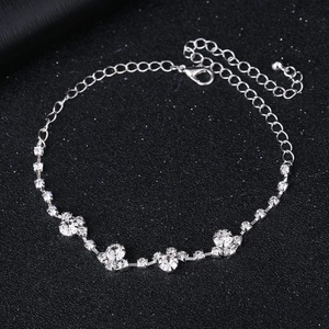 Detail eines silbernen Strass-Fußkettchens mit Kristallblüten und verstellbarem Karabinerverschluss