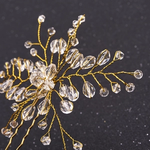 Macro shot of handcrafted gold wire branch hairpin with sparkling crystal flower beads
