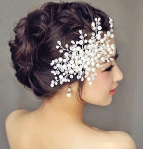 Detailed close-up of handmade bridal hair comb with elegant pearls and crystal beads on bride