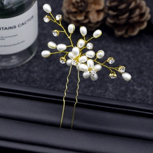 Macro shot of handmade gold floral hair pin with pearls and crystals on leather base