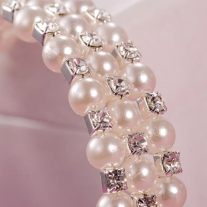 Macro detail of 6mm pearl and sparkling crystal rows on an elastic bridal bracelet