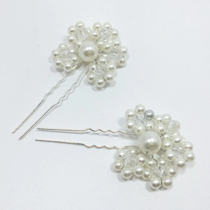 Detail of two handmade bridal U-shaped hair pins with white pearls and clear crystals