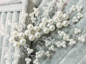 Detailed close-up of bridal hair comb with white pearls and clear crystals on silver wire