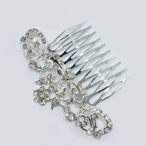 Detailed view of silver rhinestone hair comb with elegant floral scroll design for brides