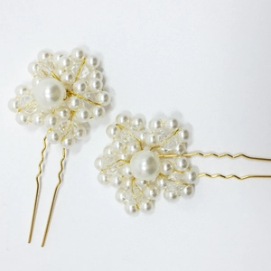 Detailed close-up of bridal U-shaped hair pins with faux pearls and crystals on gold pins