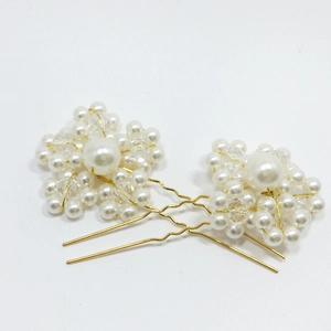 Close-up of handmade bridal U-shaped hair pins with white pearls and flower beads