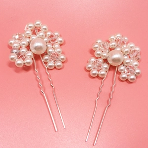 Macro detail of bridal flower hair pins with handmade white pearls and sparkling crystals