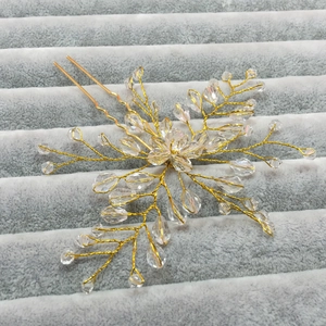 Macro detail of handmade gold wire floral bridal hair pin with clear crystal beads