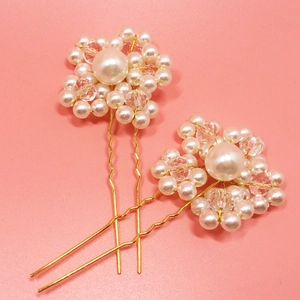 Detail of handcrafted bridal U-shape hair pins with pearls and crystals on pink background