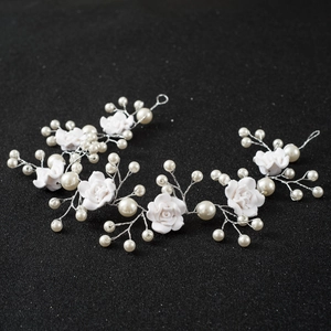 Handmade bridal headband with white clay roses and pearls on a silver vine wire