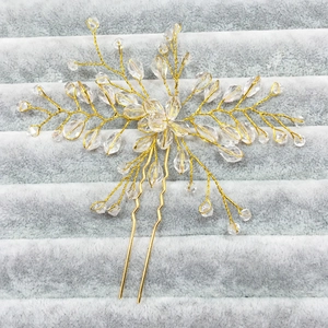 Close-up of handmade bridal U-shaped hair pin with gold wire flower and crystal beads