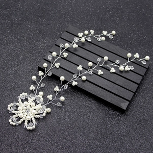 Elegant bridal hair vine with pearls and crystals on a black textured background