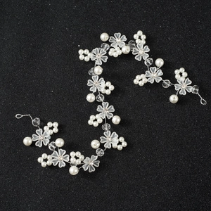 Détail de vigne de cheveux de mariée avec fleurs givrées, perles blanches et cristaux