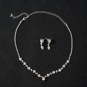 Exquisite silver-colored bridal jewelry set with sparkling rhinestones on black background