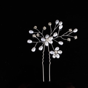 Detailed view of handmade flower hair pin with pearls and crystals on black background