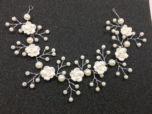 Detail of bridal headband featuring clay roses and white pearls on silver wire
