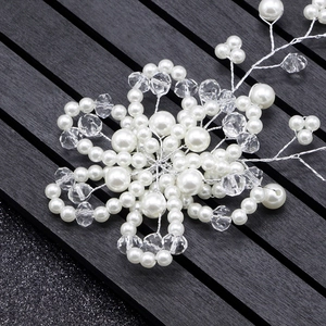 Detailed close-up of handmade bridal headband with white pearls and crystal floral accents
