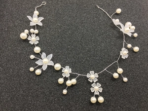 Detail of bridal headband featuring frosted resin flowers and white pearls on silver wire