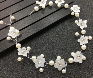 Détail d'un bandeau de mariée fait main avec fleurs givrées et perles sur fil argenté