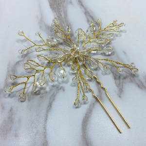 Detailed macro view of handmade gold wire floral bridal hair pin with clear crystals