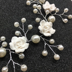 Detail macro of handmade resin rose flowers and white pearls on silver wire headband