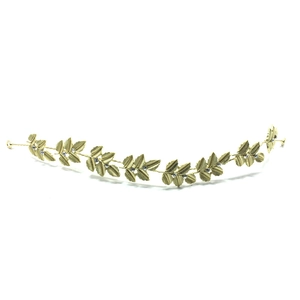 Detailed macro view of golden leaf headpiece with small white rhinestones and end loops