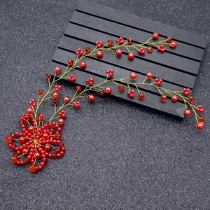 Detail of handmade red pearls and crystal beads on a golden wire wedding hair vine