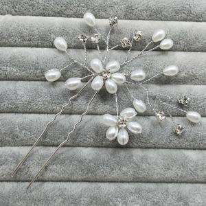 Detail of silver bridal hair pin with handmade pearls and sparkling crystal flowers