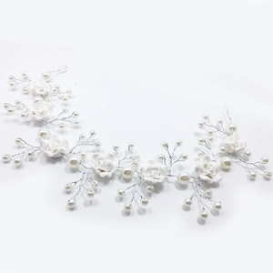 Detail of white clay roses and handmade pearls woven with silver wire for bridal hair accessories