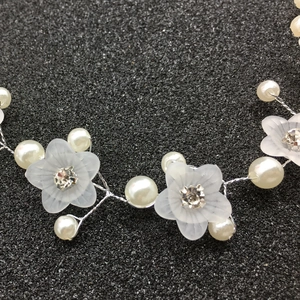 Gros plan d'un serre-tête de mariée avec fleurs givrées, perles et cristaux