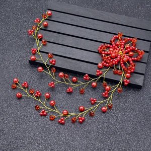 Detail showing red handmade bridal hair vine with pearls, crystals, and gold wire