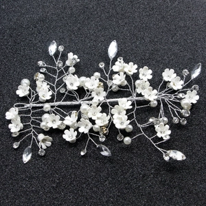 Vigne de cheveux de mariée avec fleurs blanches, perles et cristaux sur fond noir