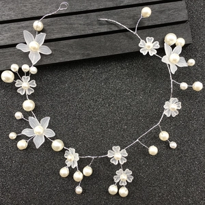 Close-up of handmade bridal headband with white pearls and frosted resin flowers