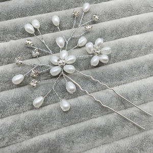 Detail showing bridal hair pin with white faux pearls and crystals on silver wire