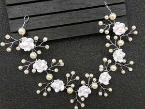 Detail of handmade bridal headband with resin flowers and pearls on silver vine wire