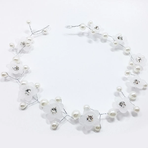 Détail d'un bandeau de mariée fait main avec fleurs mates et perles pour mariage