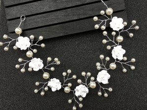 Detail view of handmade bridal hair vine with white clay roses and faux pearls on silver wire