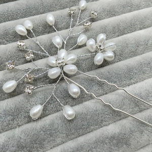 Detail of silver bridal hair pin with white pearls and sparkling crystal flowers