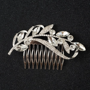Detailed macro view of silver bridal hair comb featuring marquise rhinestones and leaf design