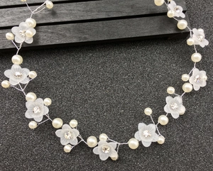 Détail d'un bandeau de mariée avec fleurs givrées et perles blanches sur fil d'argent