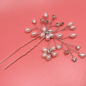 Macro detail of bridal hair pin with white pearls and sparkling crystal floral design